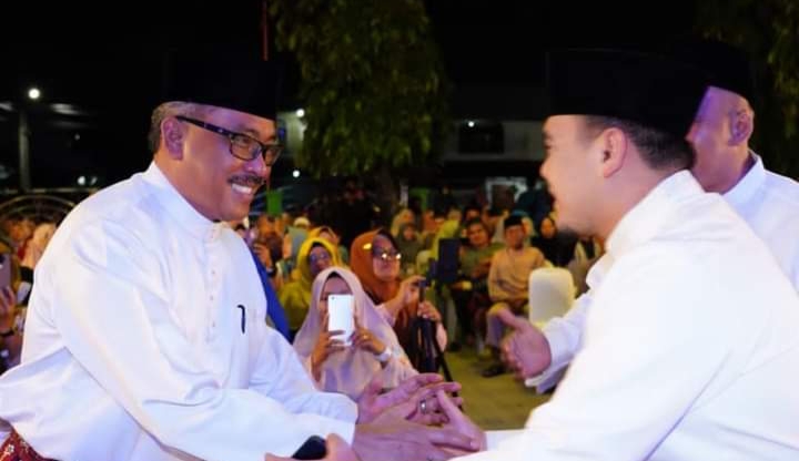 Sekdako batam Jefridin Hamid bersalaman dengan penceramah Ustaz Hilman Fauzi Nugraha dari Jakarta yang dikenal sebagai Ustaz Milenial saat Peringatan Isra Mi'raj 1444 Hijriah tingkat Kota Batam yang digelar di halaman Masjid Darul Ihsan Tanjung Sengkuang dipadati warga, Sabtu (18/2/2023) malam / F. Humas Pemko Batam