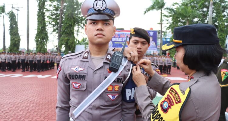 Wakapolres Karimun Kompol Petra C.K Tumengkol, S.I.K menyelamatkan pita ke salah seorang personel Satlantas Polres Karimun.