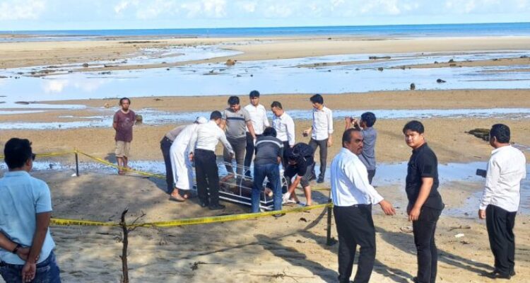 Tim Reskrim dari Polres Natuna sedang mengindentifikasi dan mengevakuasi mayat pria yang tergeletak di Pantai Piwang Natuna, Senin (23/10/2023) / F. Erwanto